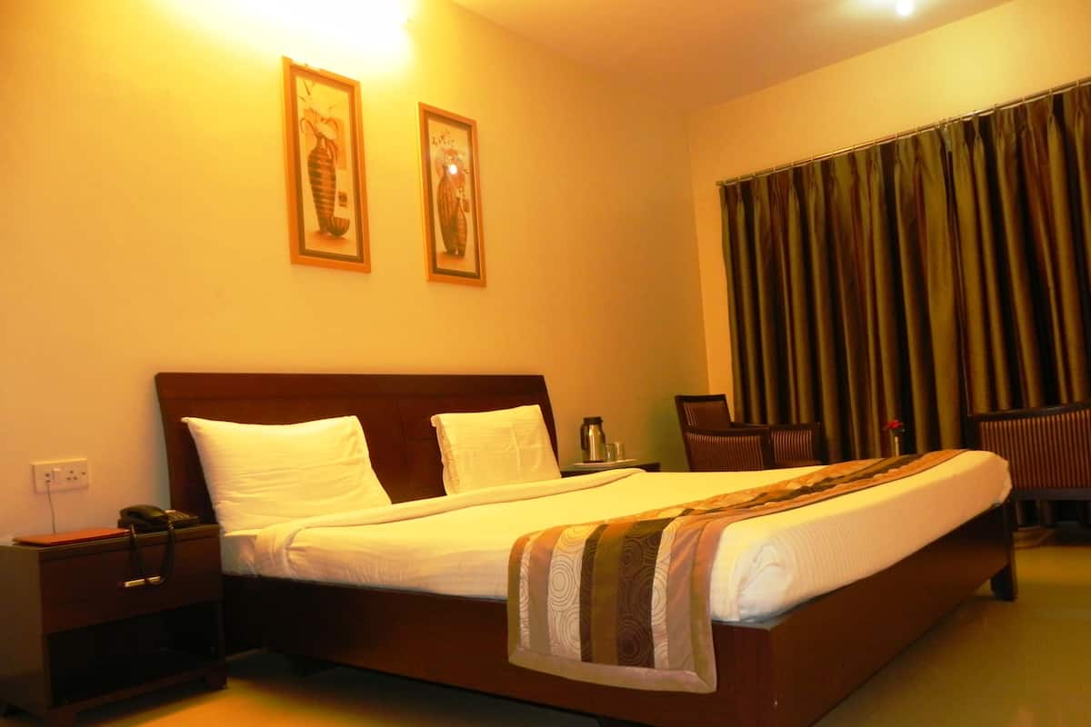 Una habitación de hotel con cama, mesitas de noche, escritorio y silla.