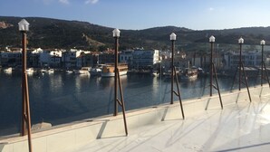 A waterfront view with buildings, boats, and a hill in the background. - Huri & Nuri Hotel (Foça)