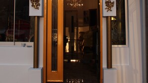 The exterior of the Huri & Nuri Hotel with a prominent entrance, a chandelier visible inside, and a red carpet leading to the door. - Huri & Nuri Hotel (Foça)
