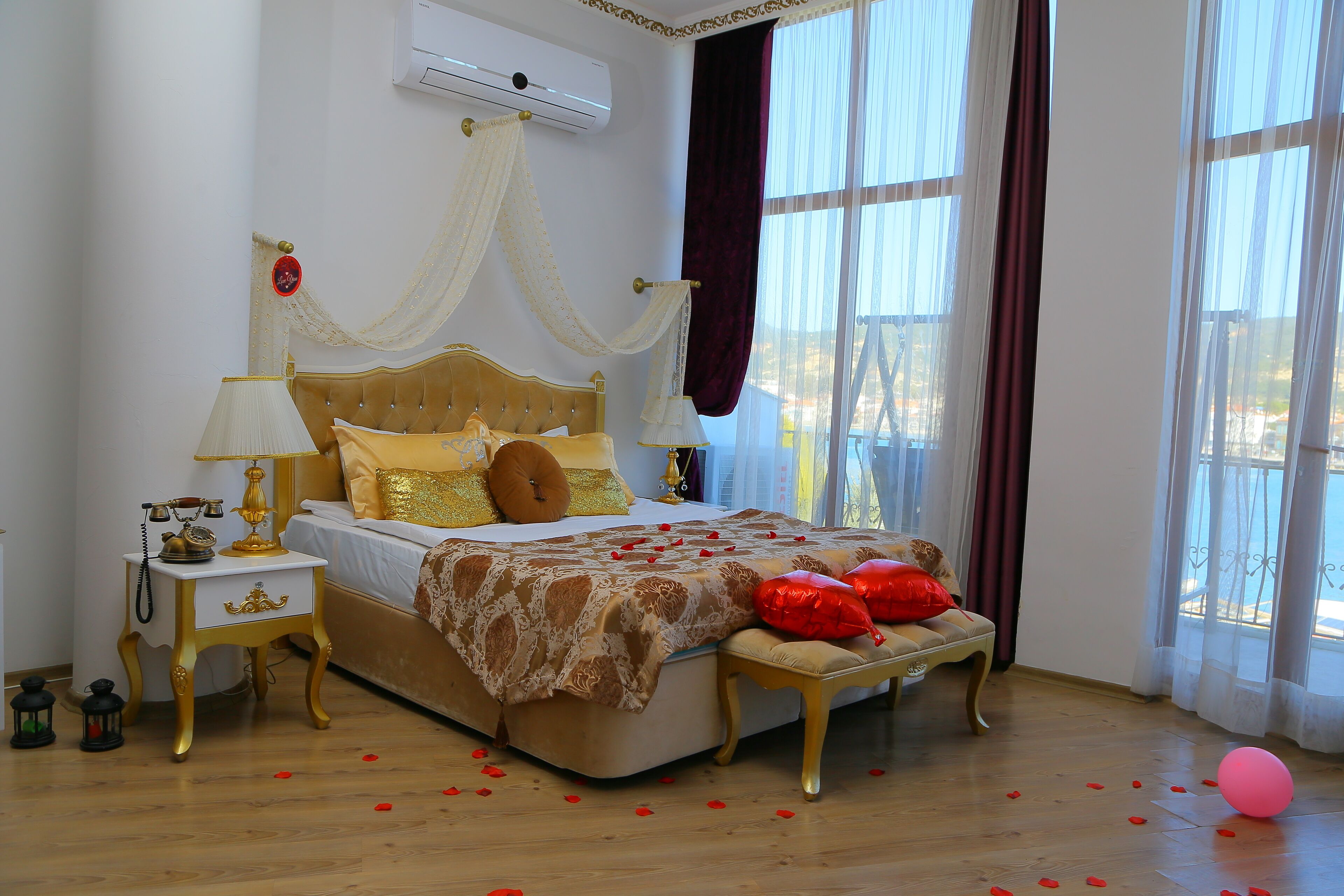 Un dormitorio ordenado con cama, mesitas de noche y una ventana con cortinas.