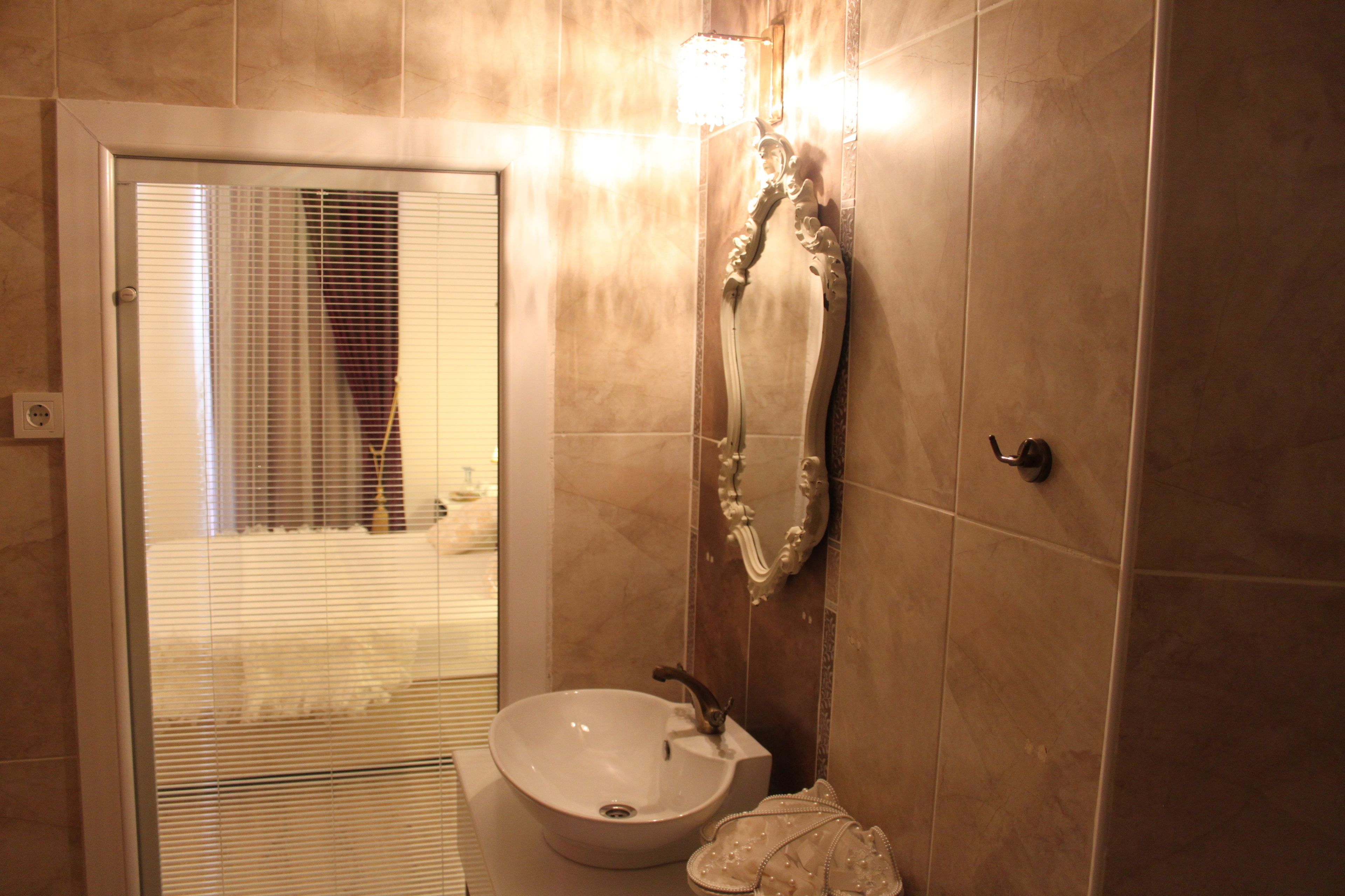 A bathroom with a sink, mirror, and shower.