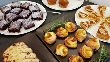 A variety of desserts including brownies, muffins, and pastries on a table.