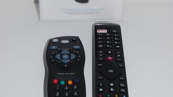 A Sky remote control box and two remote controls, one labeled 'HOTEL USE ONLY' and the other 'HITACHI'.