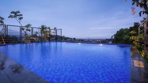 Una gran piscina azul cristalina con vistas a un paisaje urbano de fondo.