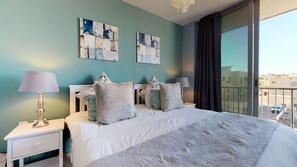 A hotel room with a large bed, two nightstands, a lamp, decorative pillows, and artwork on the walls.