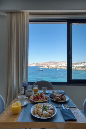 A dining table with breakfast items and a view of the sea. - Cape Mykonos (Mykonos)