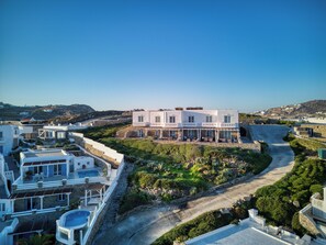 A coastal property with a swimming pool, a paved driveway, and a view of the sea. - Cape Mykonos (Mykonos)