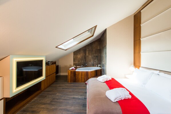 A modern hotel room with a large bed, a TV, a bathtub, and a shower. - Hotel Favori (Istanbul)