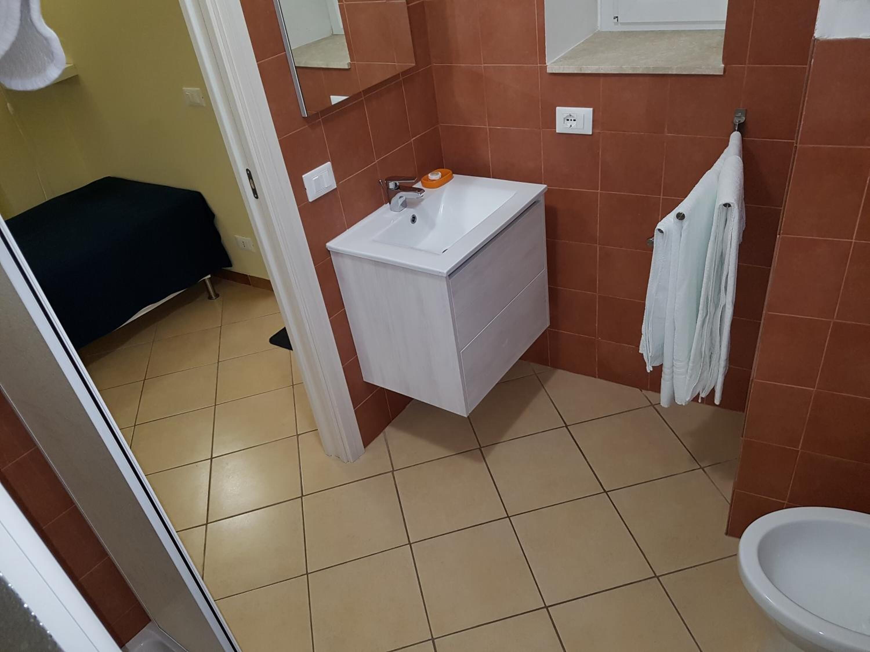 Un baño con lavamanos blanco, un espejo y un inodoro.