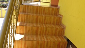 A set of wooden stairs with a metal railing, leading to a covered outdoor area. - Hotel Residencial El Viajero (Tababela)