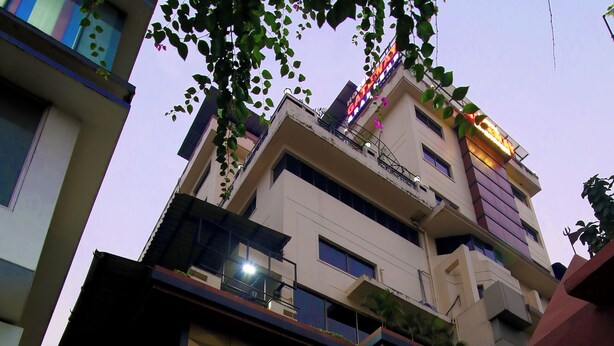 Un hotel con fachada moderna, varios pisos y una entrada destacada.