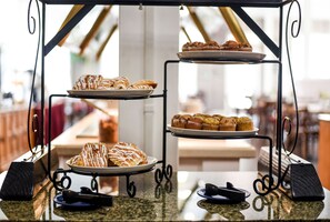 A three-tiered display stand with pastries and muffins. - Parry Lodge (Kanab)