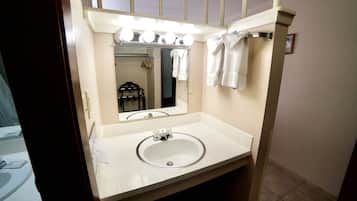 A bathroom with a sink, mirror, and vanity lights.