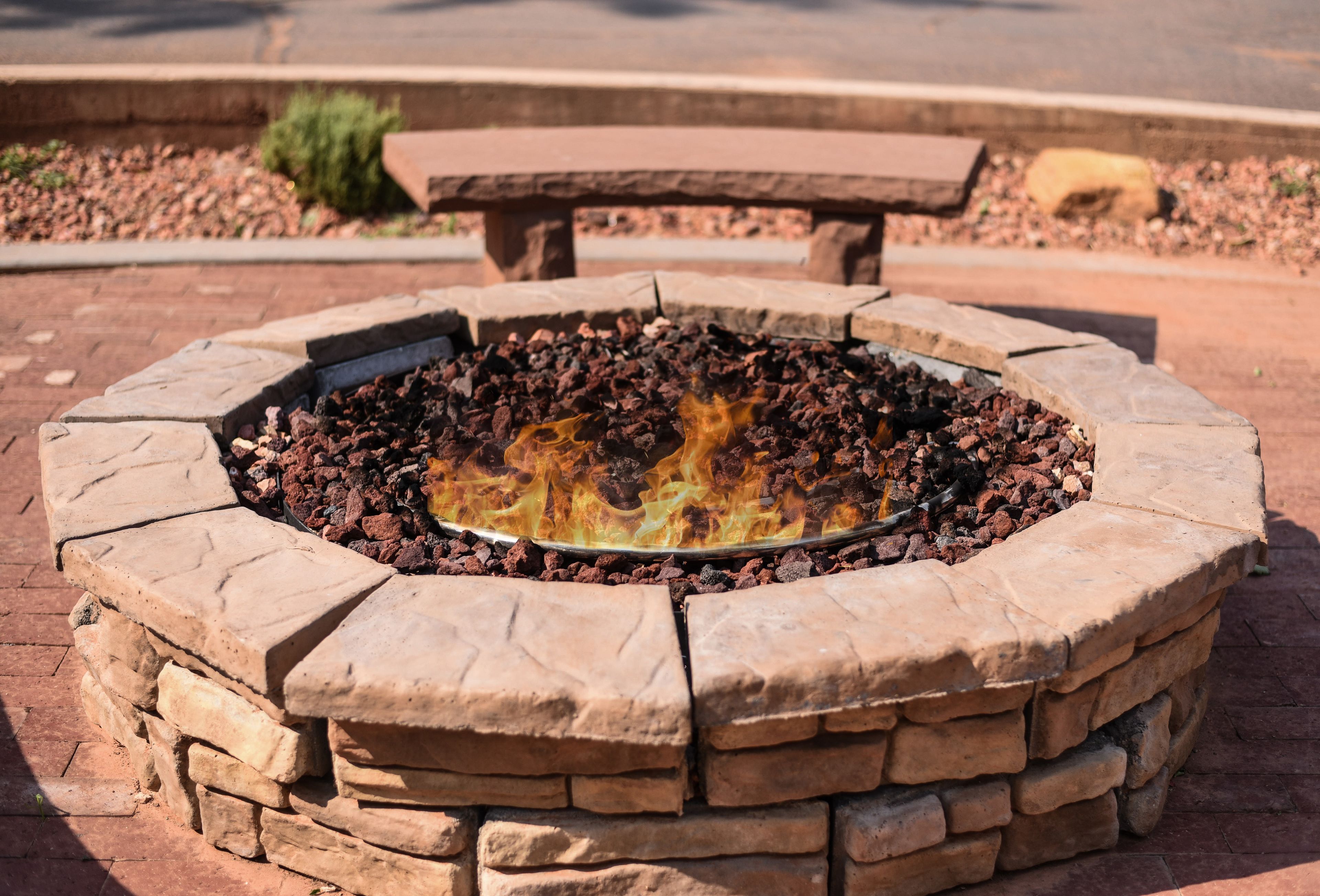 A stone fire pit with a metal fire ring, surrounded by a stone wall.