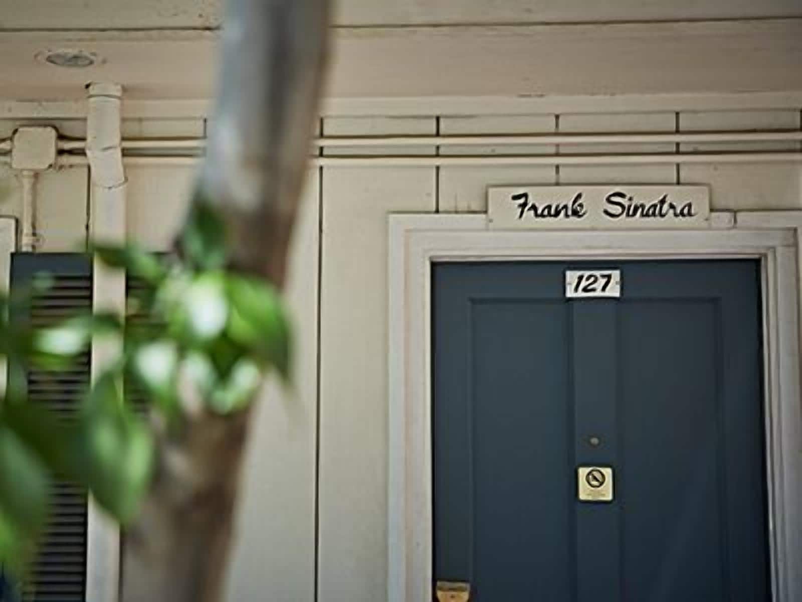 A building entrance with a door labeled "Frank Sinatra" and the number "127".