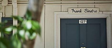 A building entrance with a door labeled "Frank Sinatra" and the number "127".