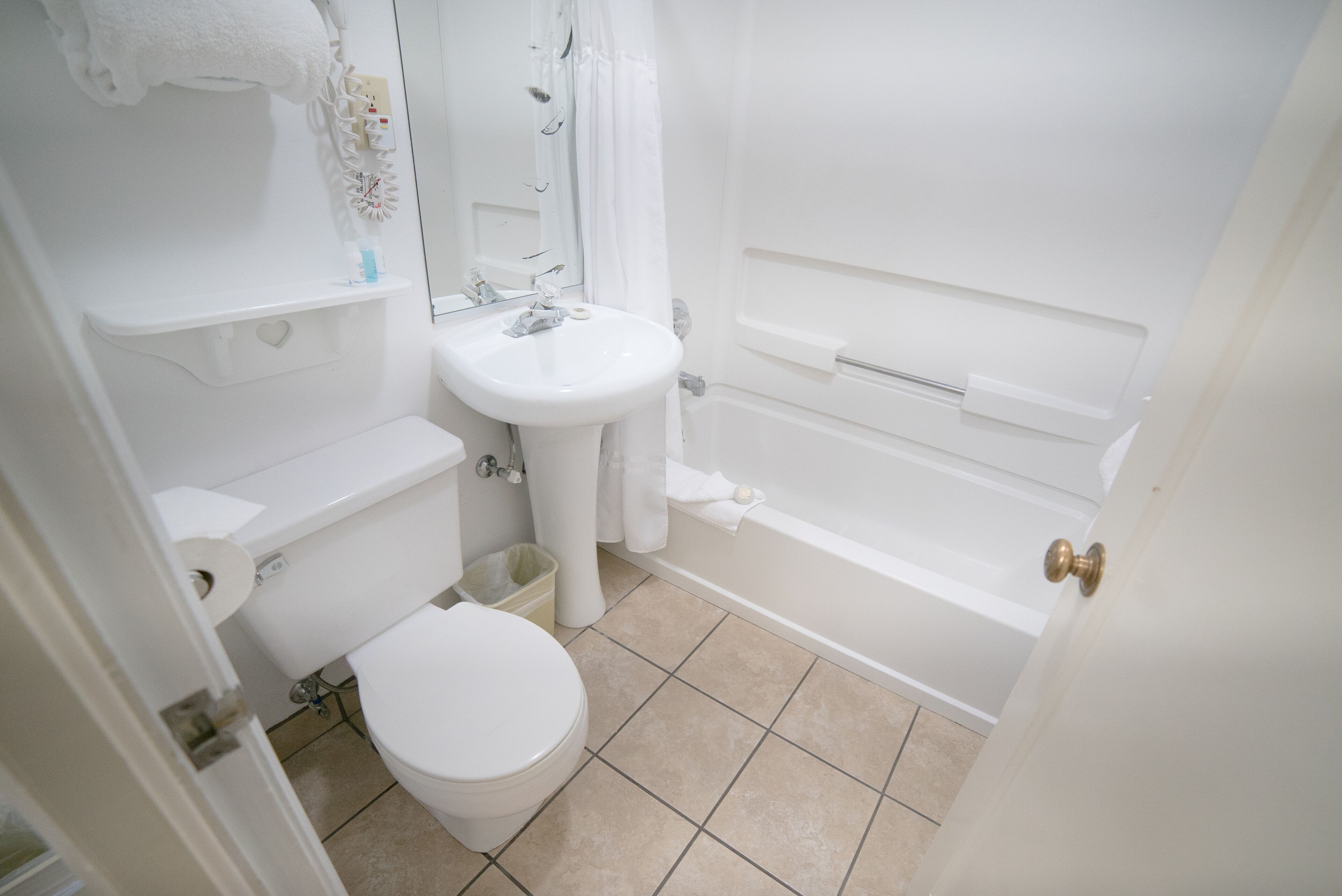 A bathroom with a toilet, sink, and bathtub.