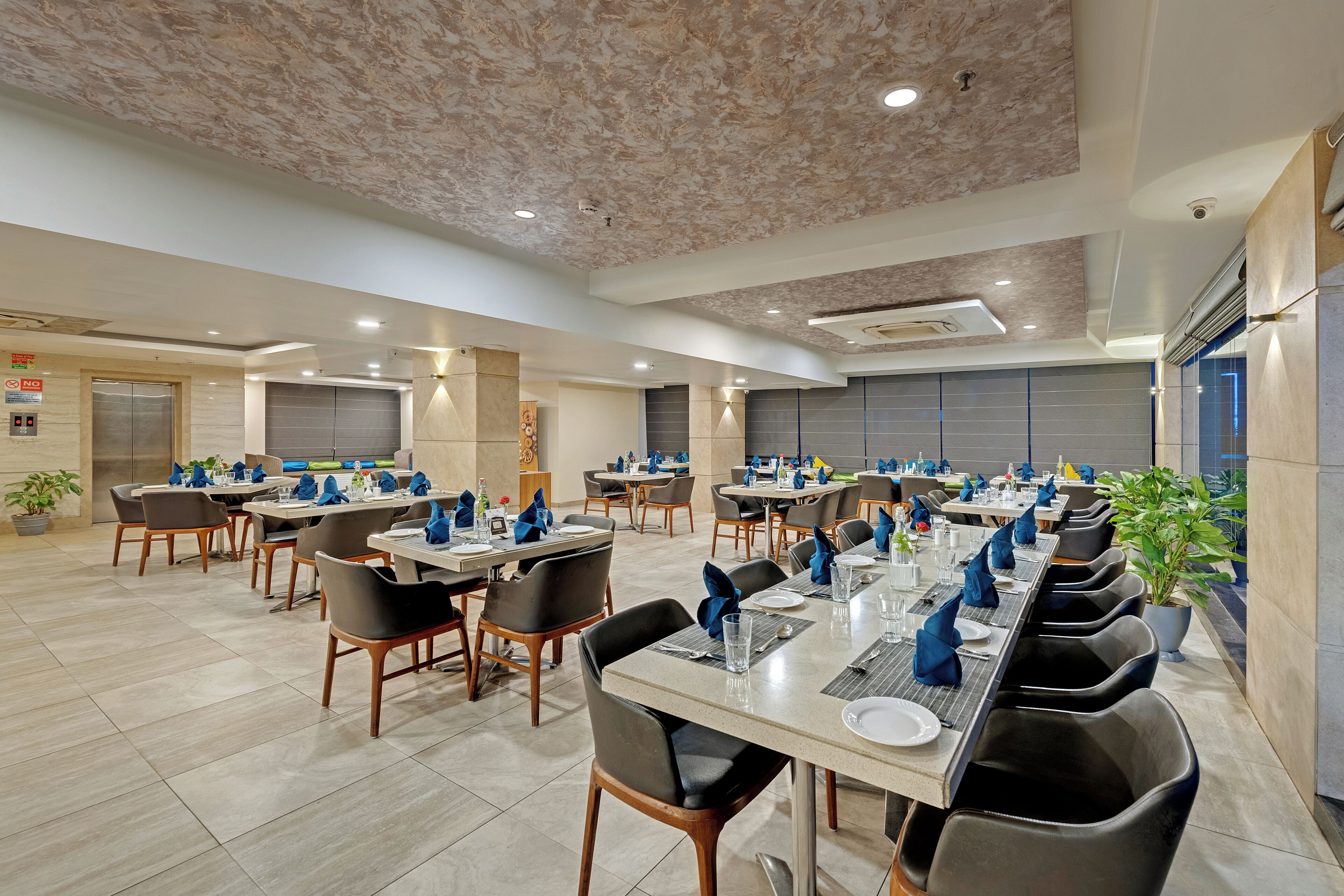 A spacious dining area with multiple tables and chairs, equipped with modern amenities.