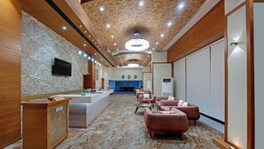 A hotel lobby with a reception desk, seating area, and a large chandelier. - Hotel Suba Elite Vadodara (Vadodara)