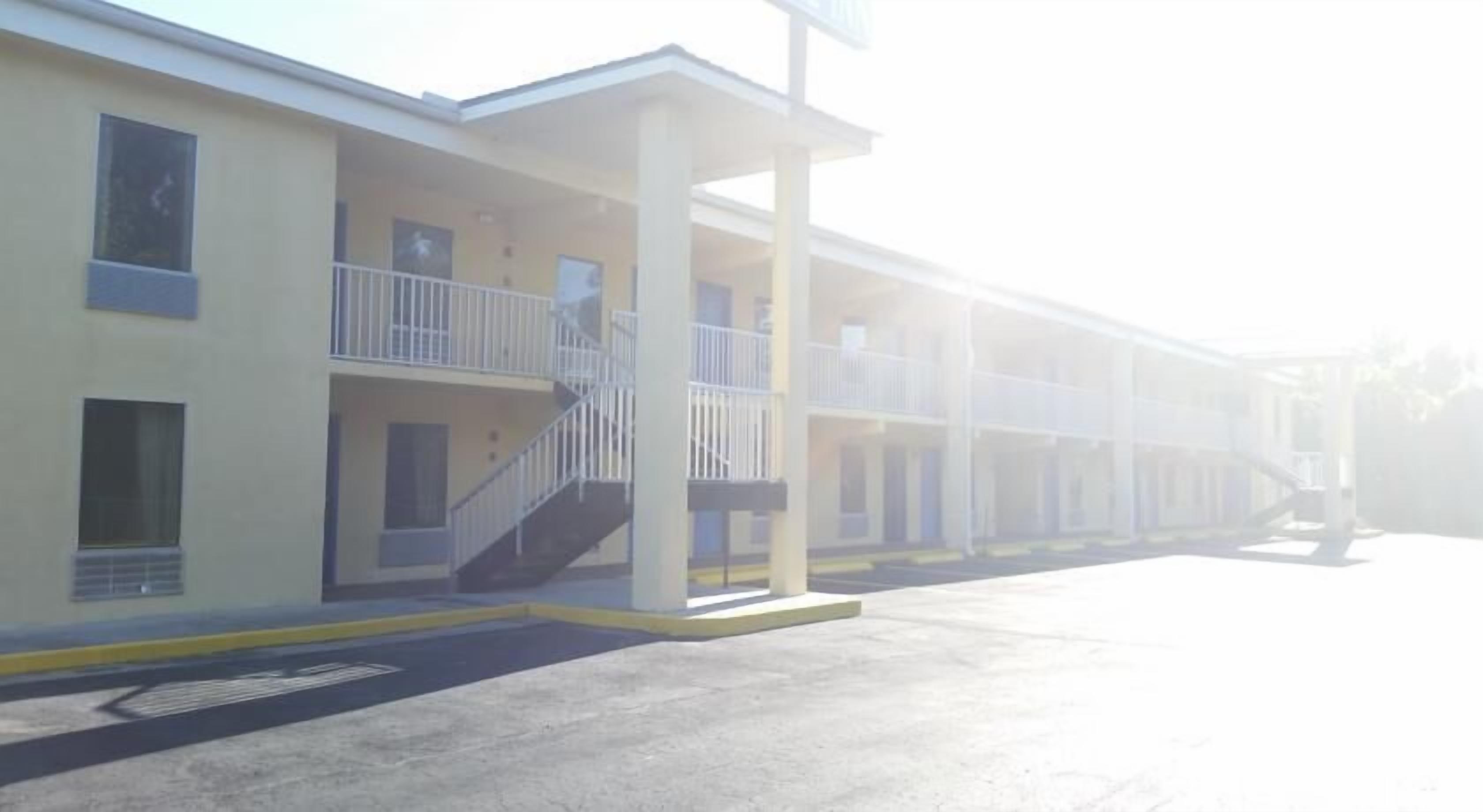 Un motel composé d’un bâtiment à deux étages, d’un espace extérieur abrité et d’un parking.
