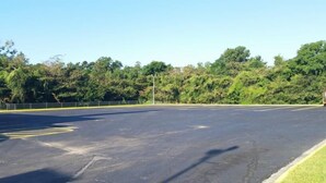 Un parking avec des voies délimitées et une zone herbeuse d’un côté.