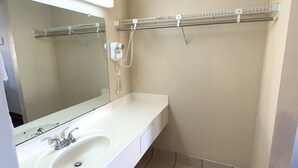 Une salle de bain avec un lavabo blanc, un miroir et un porte-serviettes.