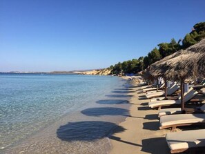 在海灘附近、白沙、躺椅、太陽傘