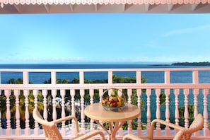 A balcony with a round table and wicker chairs, overlooking a coastal view. - Bahia Principe Escape Samaná - Hyatt Inclusive Collection - Adults Only (Samaná)