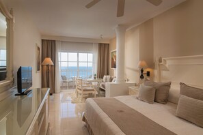 A hotel room with a bed, a TV, a desk, and a view of the sea. - Bahia Principe Escape Samaná - Hyatt Inclusive Collection - Adults Only (Samaná)