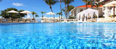 Una piscina al aire libre, sillones reclinables de piscina