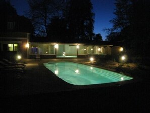 Ein modernes Haus mit Swimmingpool im Abenddämmerung.