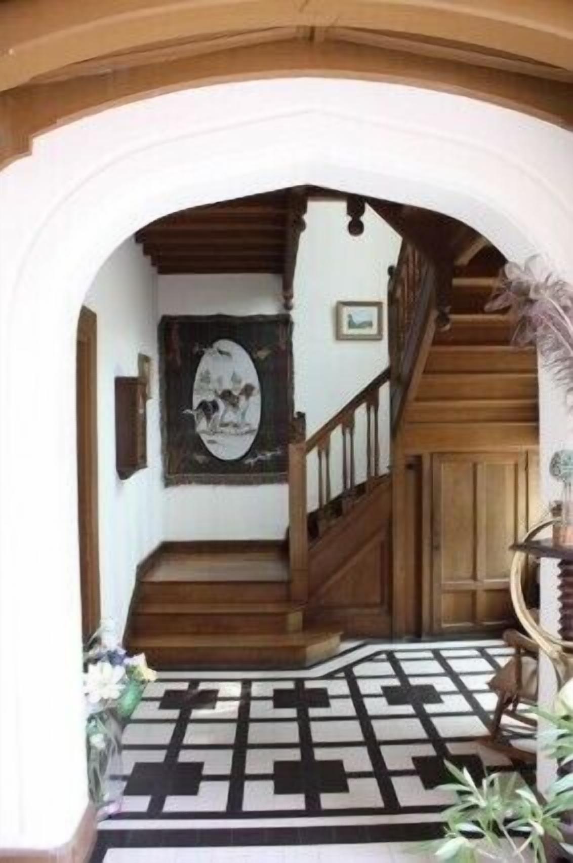 A staircase with wooden railings and a patterned floor.