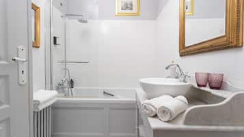 Un baño moderno con bañera, lavamanos y cabina de ducha.
