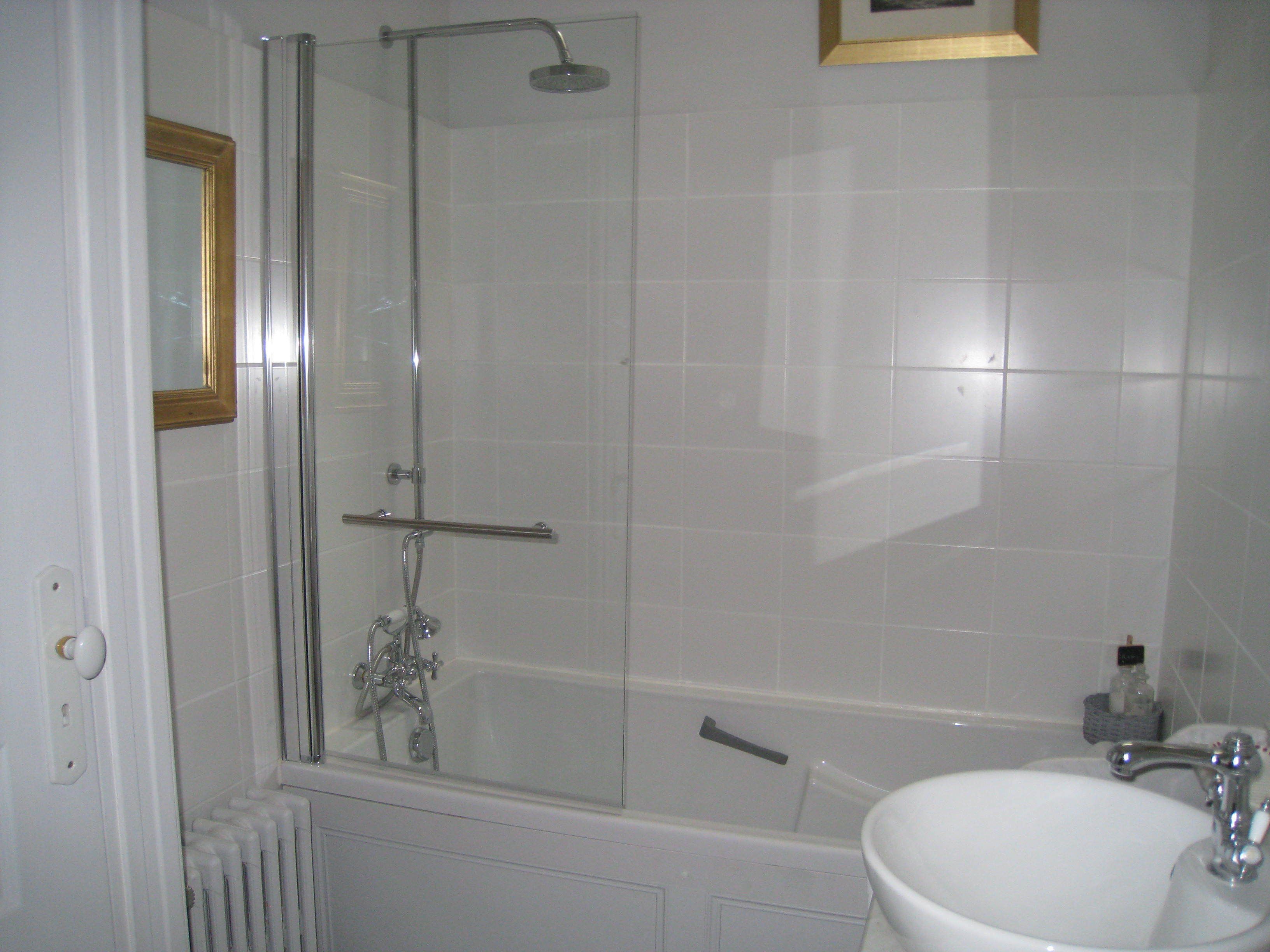 Une salle de bain avec une douche à parois de verre, une baignoire et un lavabo.