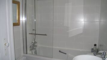 Une salle de bain avec une douche à parois de verre, une baignoire et un lavabo.