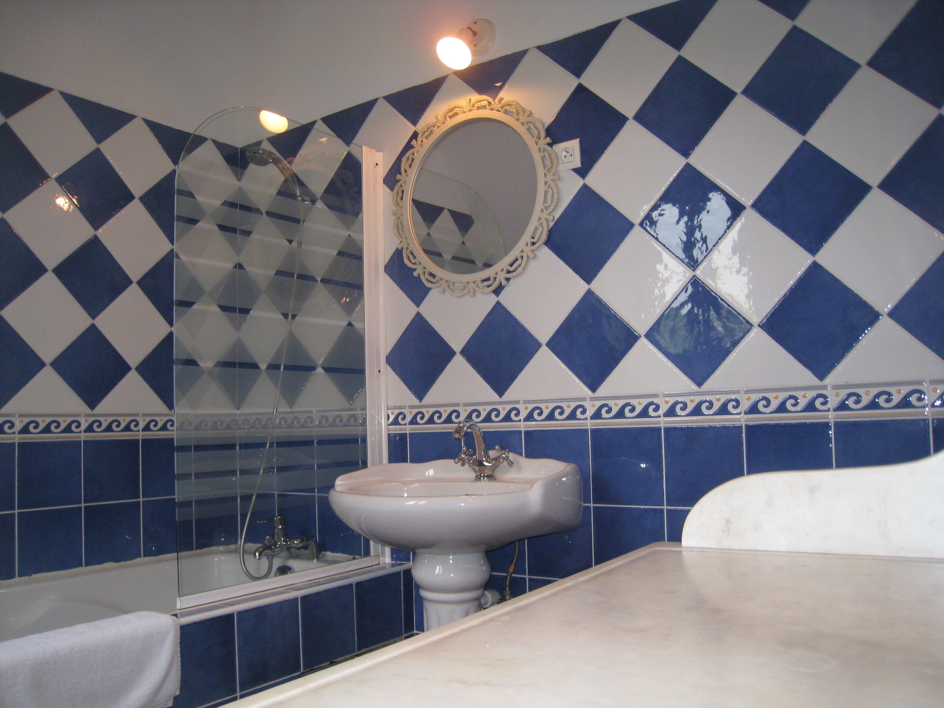 A bathroom with a sink, mirror, and bathtub.