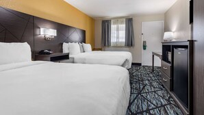 A hotel room with two beds, a desk with a lamp, a minibar, and a window with curtains. - Quality Inn Cameron (Cameron)