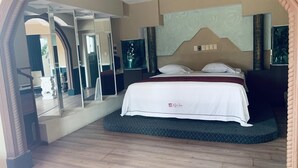 A hotel room with a bed, a large mirror, and a view of the outside. - Hotel Rio Inn (Boca del Río)