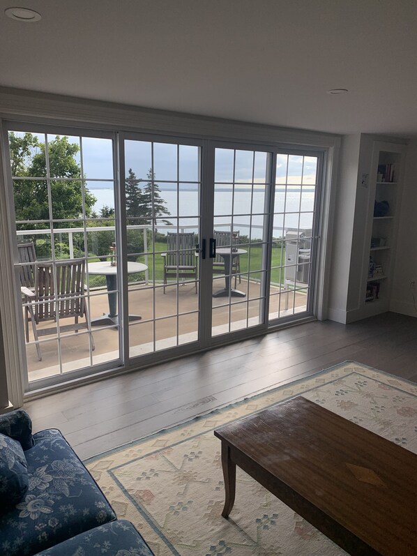 A room with a large sliding glass door leading to an outdoor patio area.