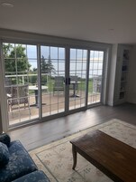 A room with a large sliding glass door leading to an outdoor patio area.