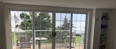 Una habitación amplia con un gran ventanal corredizo que da a un patio exterior.