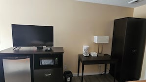 A hotel room with a desk, a television, a coffee maker, a microwave, and a wardrobe. - Town N Country Motor Inn (Leamington)
