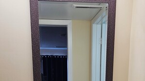 A bathroom with a white sink, dark wooden vanity, and a mirror with a textured frame. - Town N Country Motor Inn (Leamington)