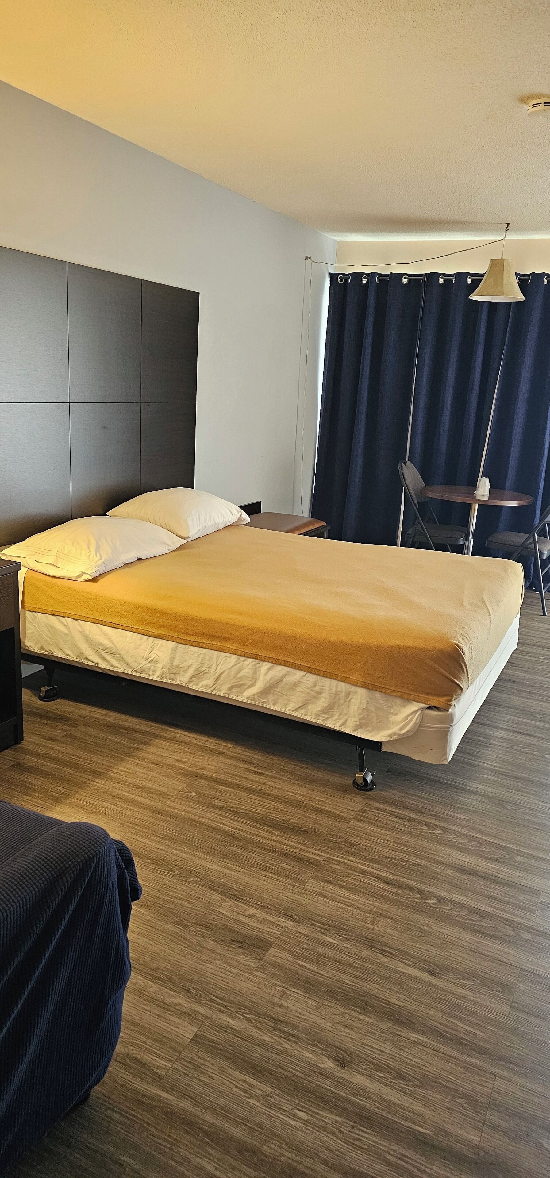 Una habitació d'hotel amb un llit, un escriptori, una cadira i una taula.