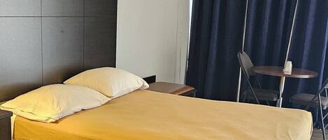 Une chambre d’hôtel avec un lit, un bureau, une chaise et une table.