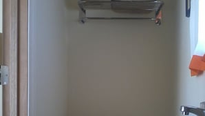 A small bathroom with a toilet, a sink, and a towel rack. - Hiland Terrace Hotel (Irwin)