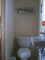A small bathroom with a toilet, a sink, and a towel rack.