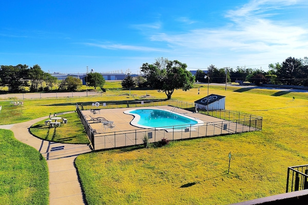 Una piscina al aire libre de temporada, sillones reclinables de piscina