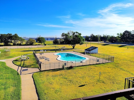 Una piscina al aire libre de temporada, sillones reclinables de piscina