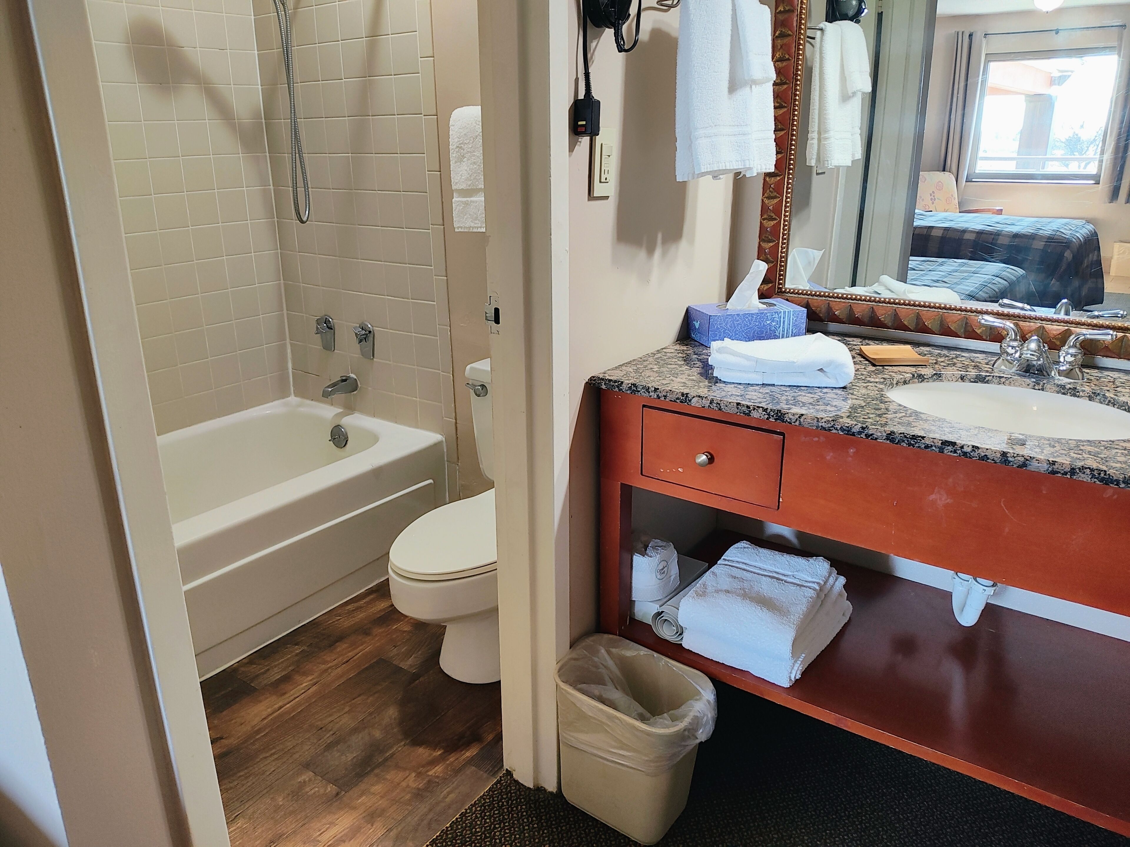 Un baño con bañera, inodoro, lavabo y espejo.